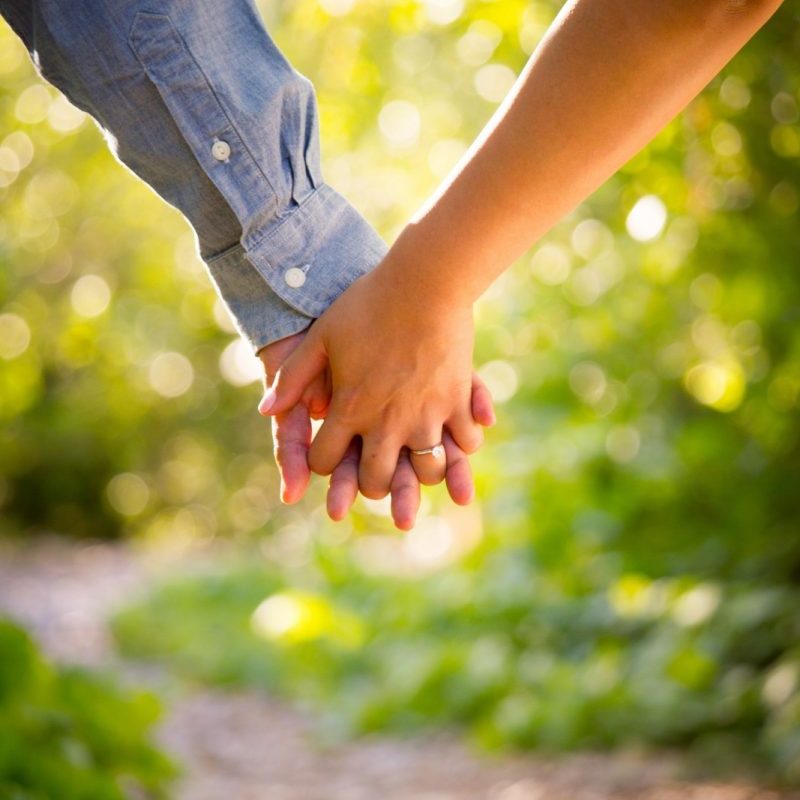 shallow focus photo of man and woman holding hands